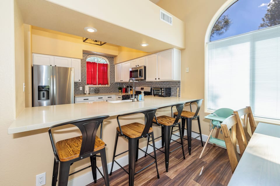 4 stools at the breakfast bar, which is adjacent to the kitchen and dining room table.