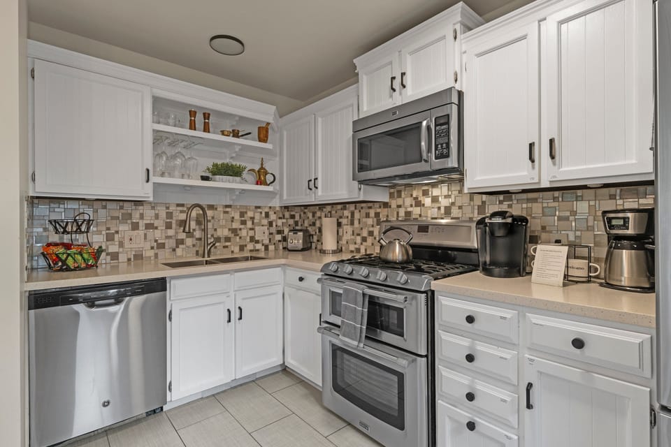 Cook with ease in the fully-stocked kitchen, complete with stunning quartz countertops, a 2-barstool peninsula, and stainless-steel appliances.