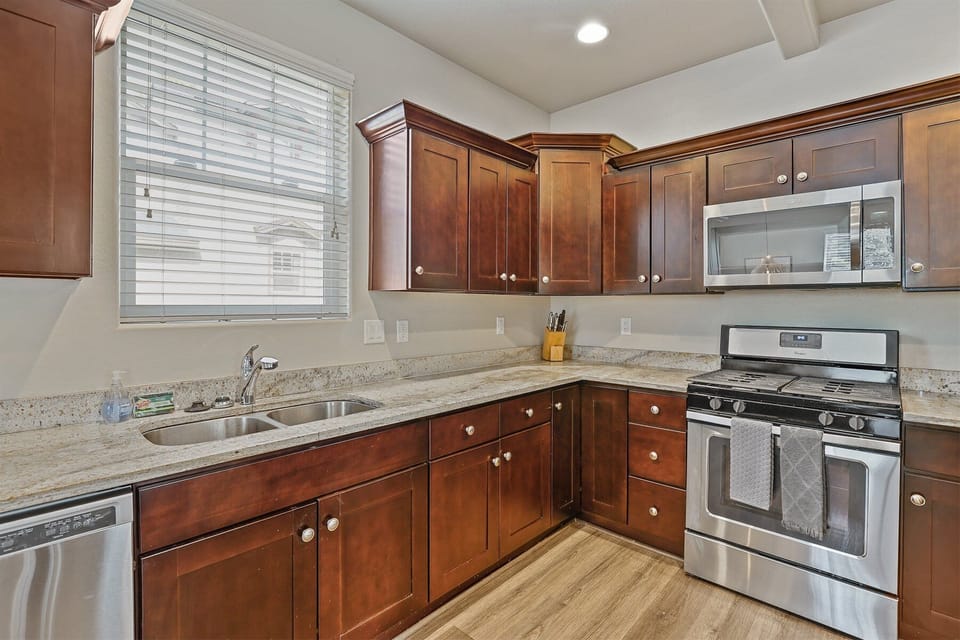 Create memorable meals in this fully equipped kitchen featuring premium appliances, dark wood cabinets, and ample counter space.