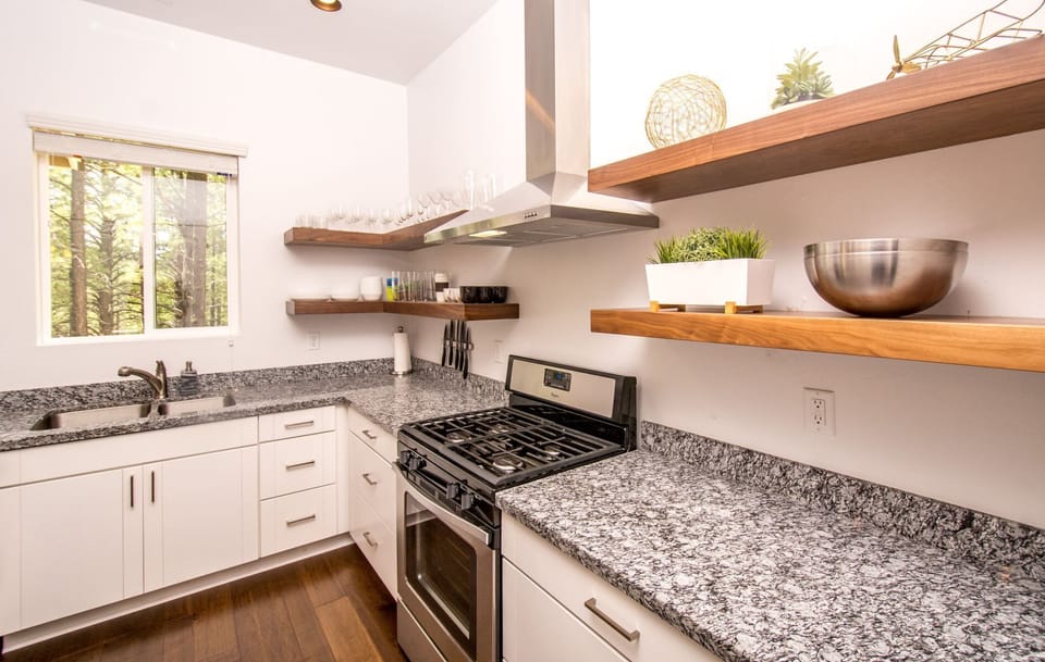 The kitchen boasts beautiful granite countertops, all stainless steel appliances, a gas range, recessed lighting, and a large pantry.