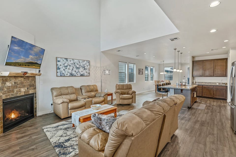 2 leather sofas and a leather lounge chair surrounding a lovely wooden coffee table. A smart, flat screen TV with HD antenna rests above the gas fireplace