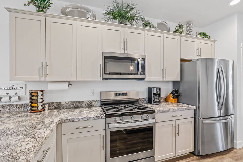 Fully equipped for your convenience, this modern kitchen features a refrigerator, stove, oven, microwave, and coffeemaker – everything you need to feel at home.