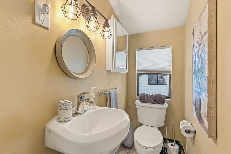 A charming and well-lit half bathroom with warm decor and modern touches.
