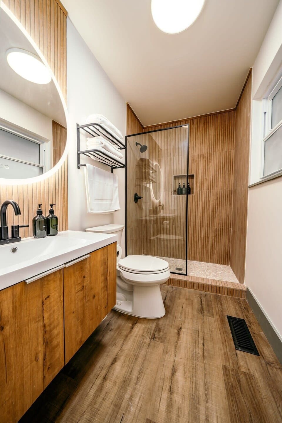 Private bathroom with a glass shower and a light-up vanity mirror.
