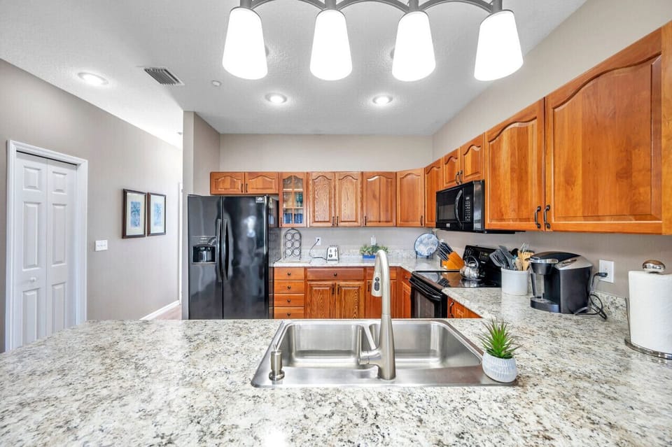 Bright kitchen w/ granite counters, wood cabinets, and everything set up for easy meal prep.