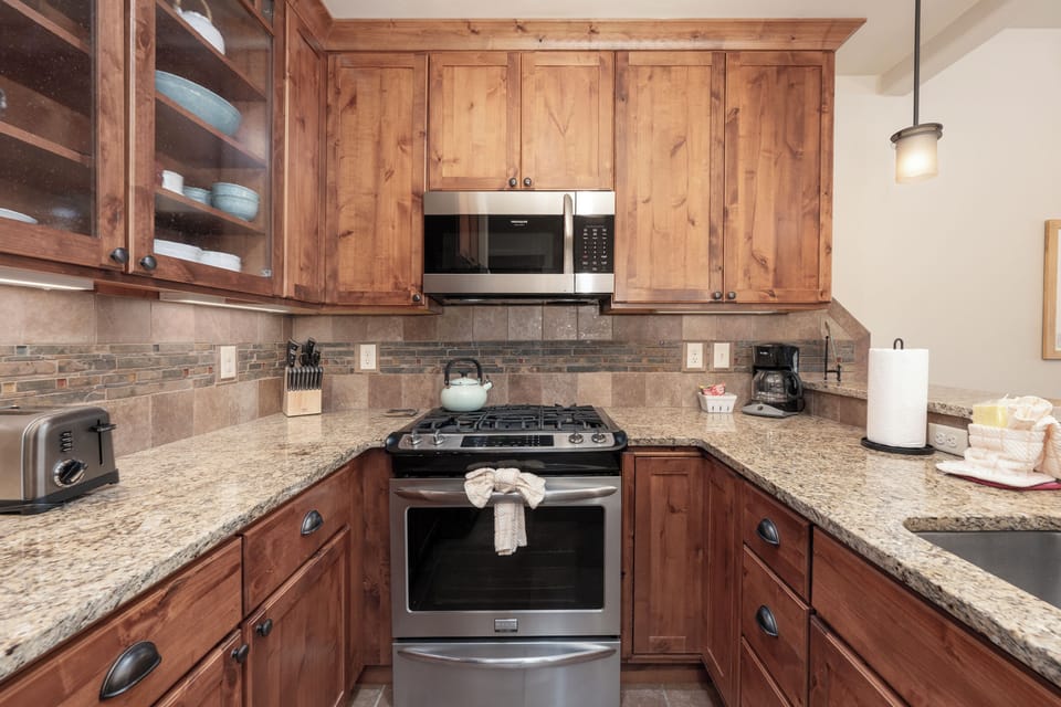 Your fully equipped kitchen features warm wood cabinetry, granite counters, and modern appliances perfect for preparing memorable meals during your stay.