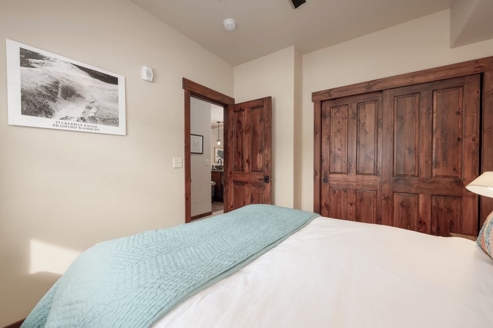 Sink into crisp white linens and soft mint accents in your peaceful bedroom retreat, complete with rustic wood details and ample storage.