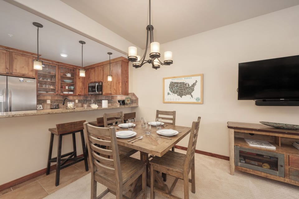 Your open-concept space seamlessly blends kitchen and dining, perfect for preparing meals and gathering around the rustic wood table.