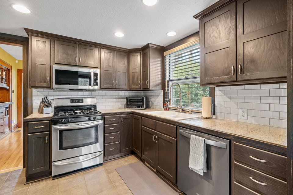 Your fully equipped kitchen features rich wood cabinets, stainless steel appliances, and granite countertops perfect for preparing meals.