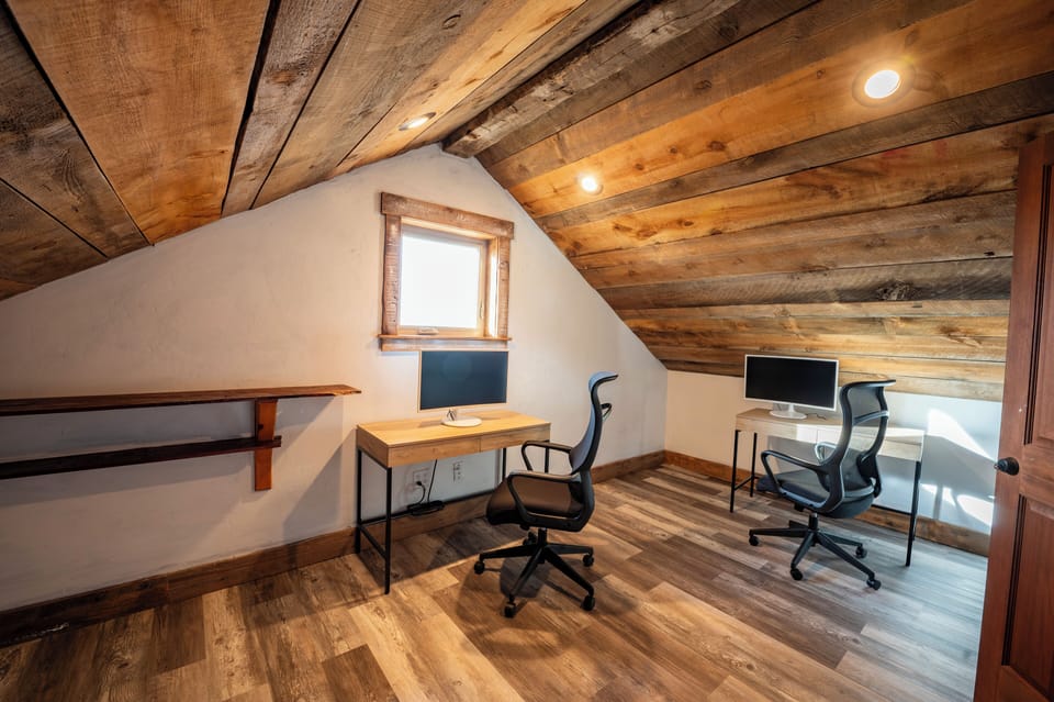 The office with room for two with two desks, two monitors and printer.