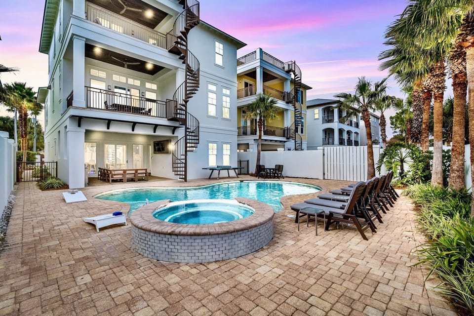 Sunset Manor—your perfect group getaway that SLEEPS 26! Just steps from PRIVATE beach access, this stunning retreat includes a FREE golf cart. Unwind in the backyard oasis with a heated pool, hot tub, outdoor kitchen, and lounge seating. Plus a game room!