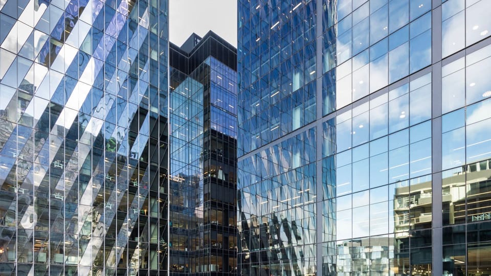 Towering glass facades right outside your window showcase a stunning urban landscape.