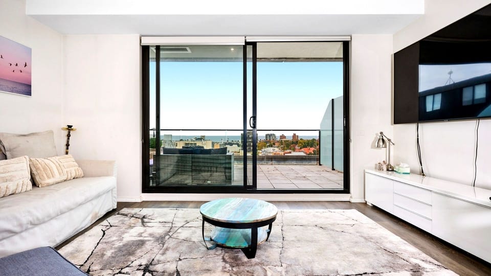 Oversized sliding glass doors frame expansive neighborhood views, flooding the lounge with natural light