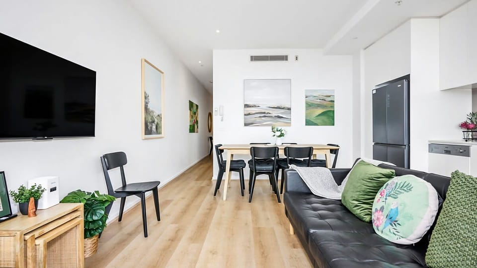 A spacious, highly functional living and dining zone boasting beautiful light-timber flooring and crisp white walls.