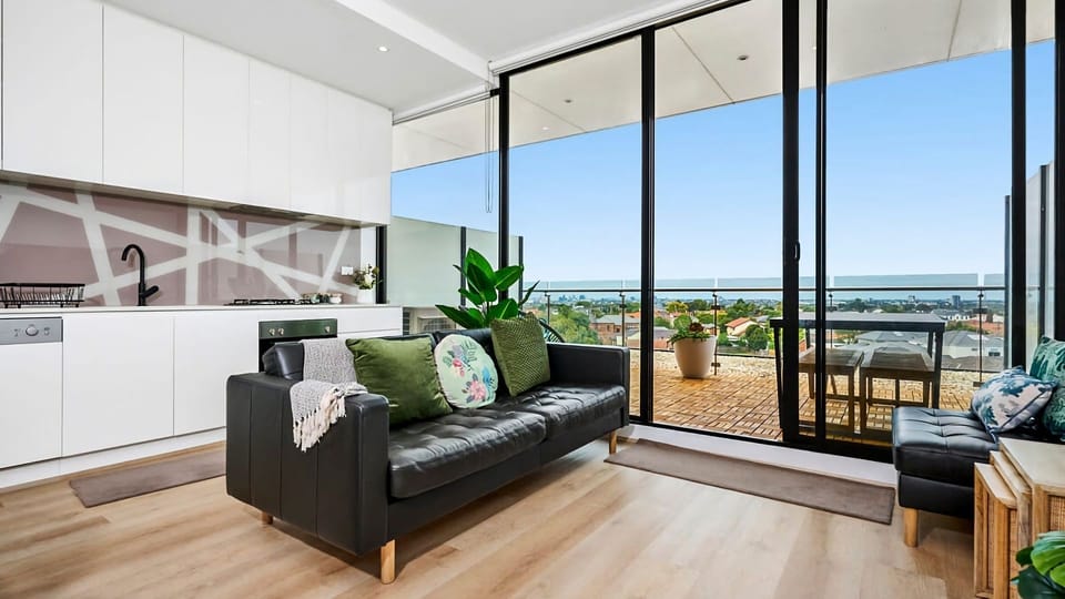Experience seamless indoor-outdoor harmony with floor-to-ceiling glass doors connecting your chic lounge to the terrace.