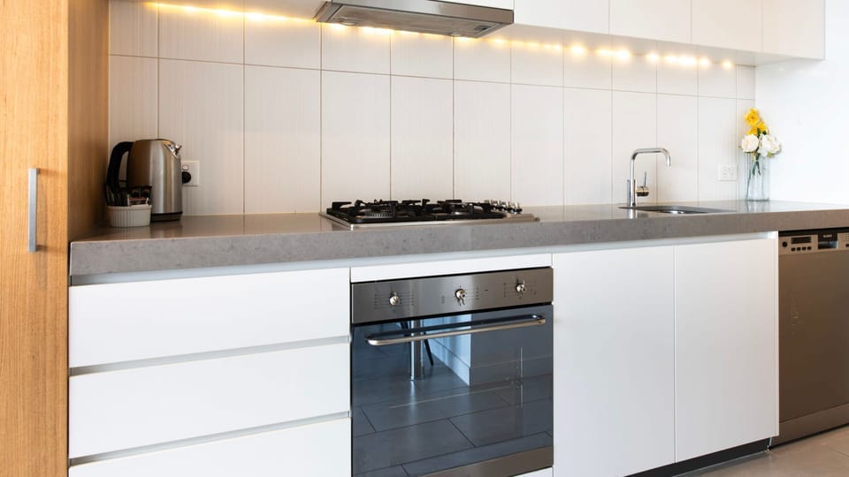 Fully equipped designer kitchen with premium appliances and clean minimalist style.