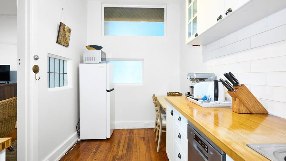 A streamlined view of the sun-drenched kitchen, emphasizing its clean lines and practical workflow.