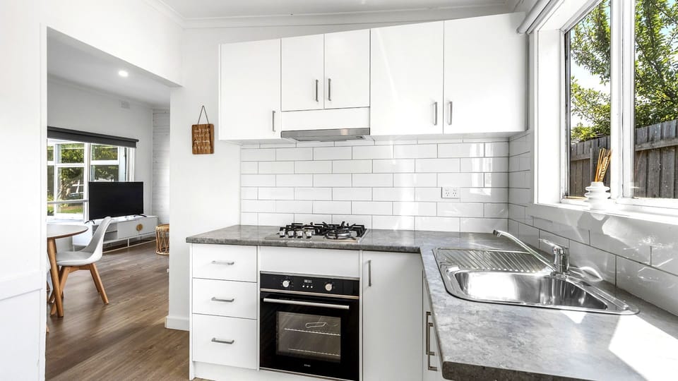 Cook with ease in this bright, contemporary kitchen boasting crisp white cabinetry and modern appliances.