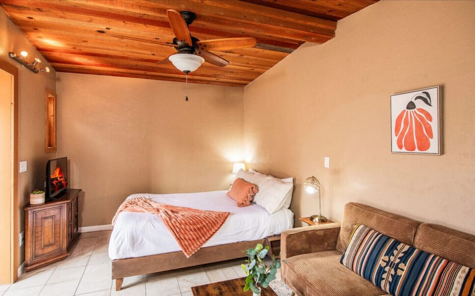 Relax in this inviting space featuring a cozy queen bed, smart TV, and warm wood-beamed ceilings. Whether you’re unwinding after a day of exploring or enjoying a quiet night in, comfort and charm await you here.