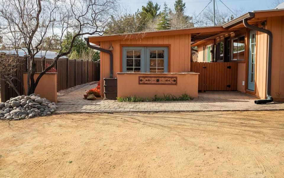 This warm and inviting exterior welcomes you with charm, earthy tones, and cozy touches—perfect for relaxing after a day of adventure. A peaceful retreat awaits behind the gate!