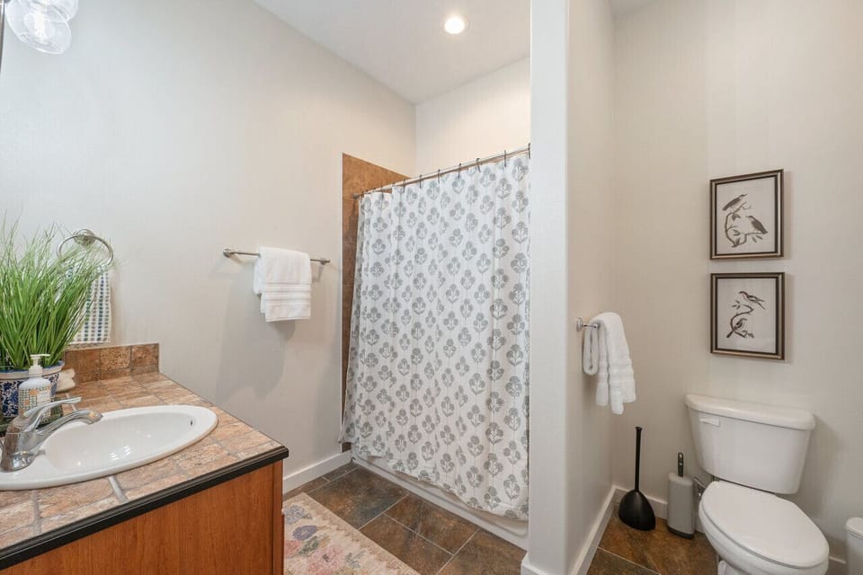 Stylish shared bathroom equipped with plush towels, fragrant soaps, and a relaxing tub-shower combination.