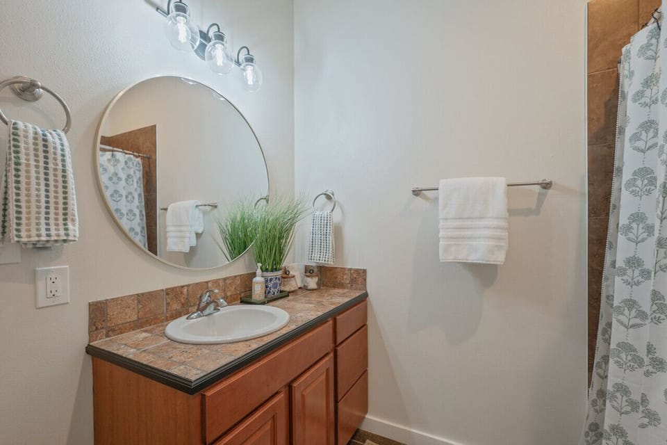 Stylish shared bathroom equipped with plush towels, fragrant soaps, and a relaxing tub-shower combination.