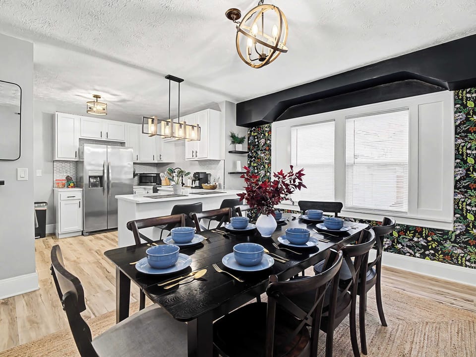 Elegant dining table set for a group beside the bright open kitchen