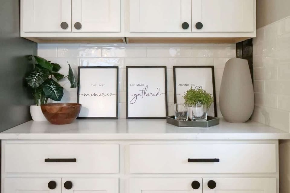 Stylish kitchen shelf decor w/ framed art, plants & simple accents