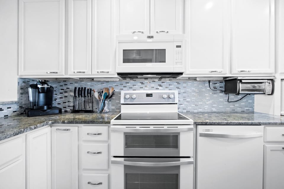 Modern kitchen fully equipped with stainless steel appliances and sleek cabinetry.