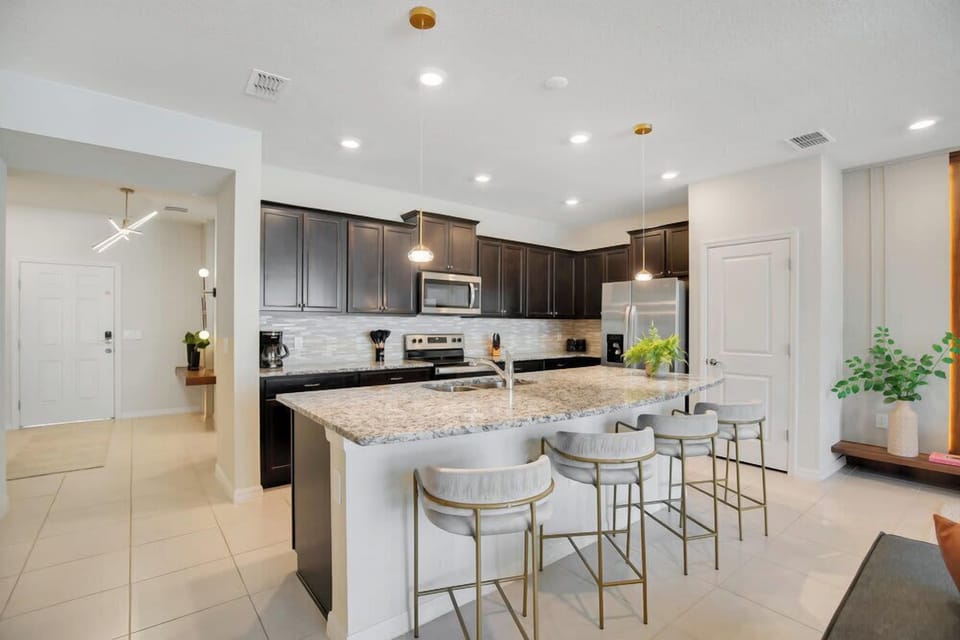 Modern kitchen with granite island and seating for four.