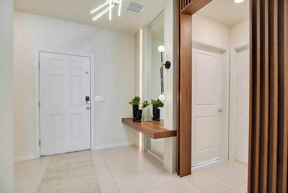 Modern entryway with a floating wood console and decorative lighting.