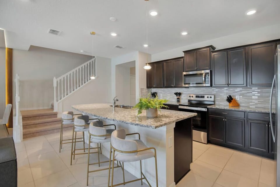 Modern kitchen with granite island and dark cabinetry for a sleek cooking experience