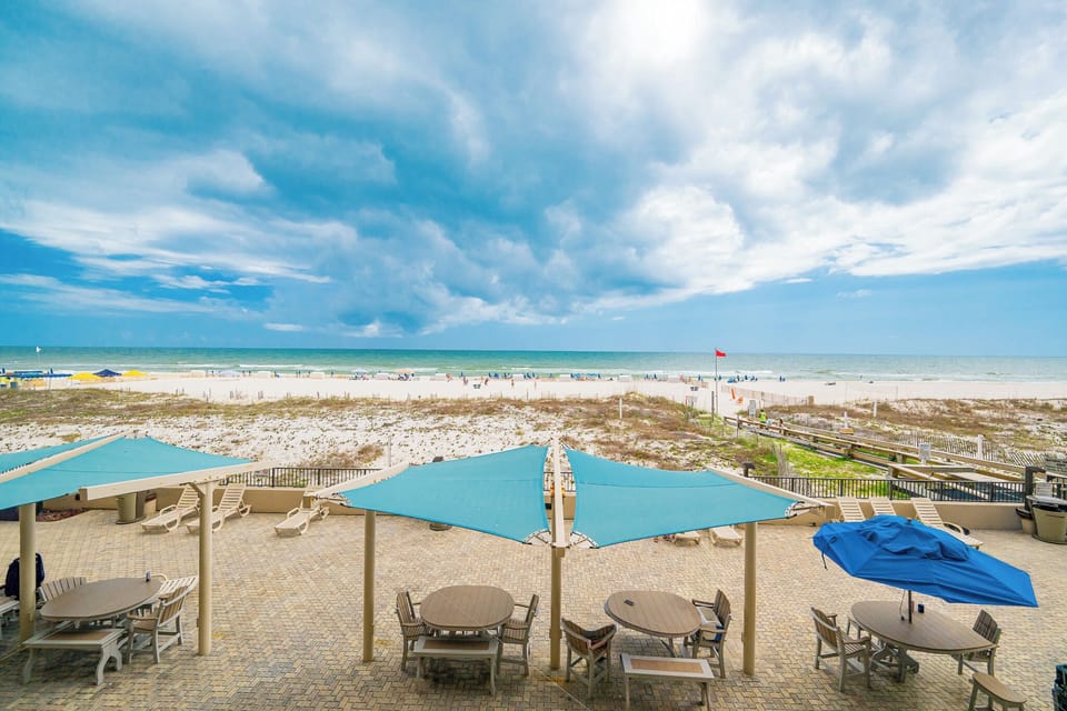 Colorful umbrellas and soft crashing surf spread before you from this peaceful beachfront view
