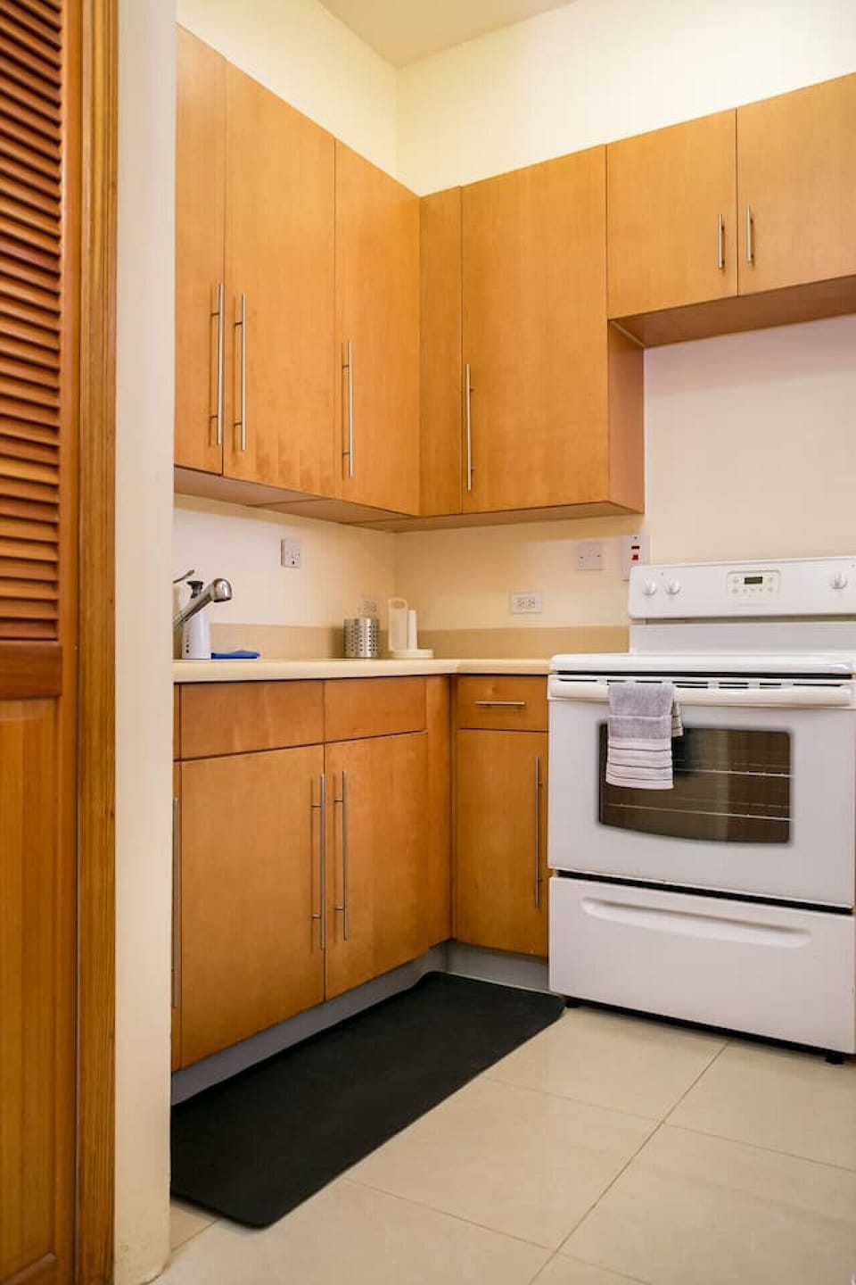Kitchen corner w/ stove, countertop & wood cabinets for convenient meal prep.