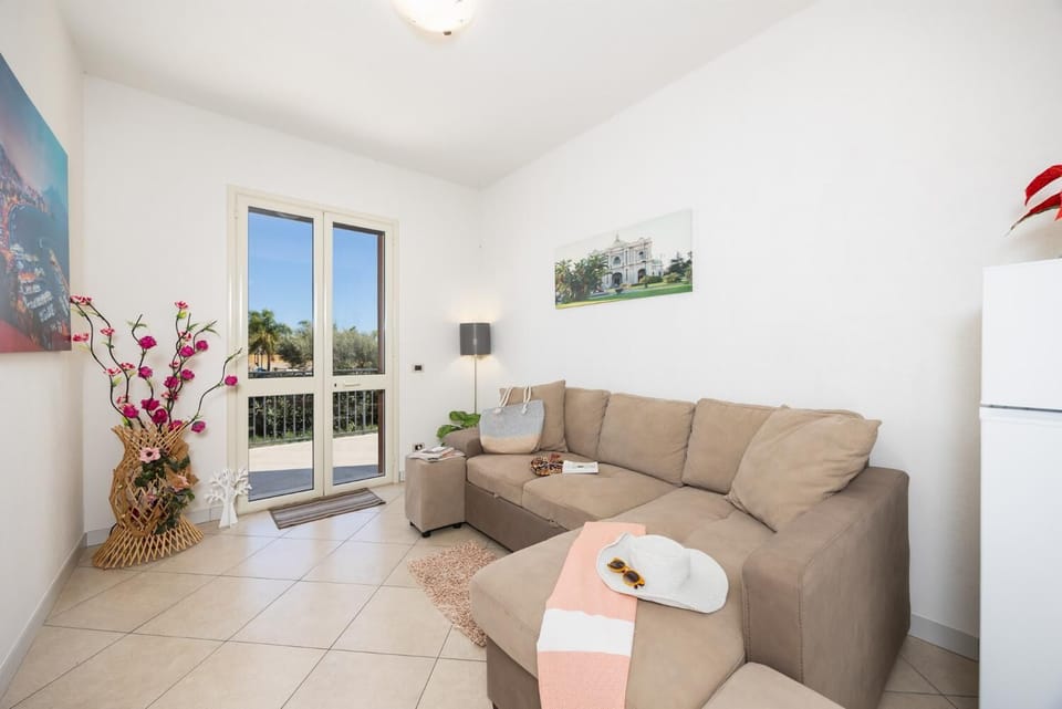 Open-plan living room with sofa, dining area, kitchen, A/C, WiFi internet, and satellite TV