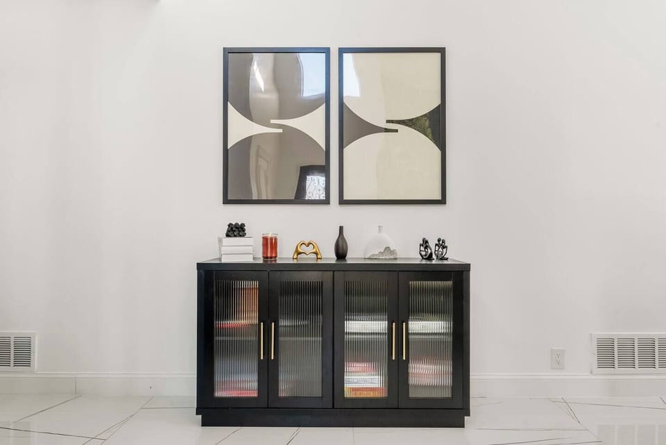A sleek modern credenza paired with a vibrant showcase of contemporary artwork creates a stylish and inspiring focal point in the space.