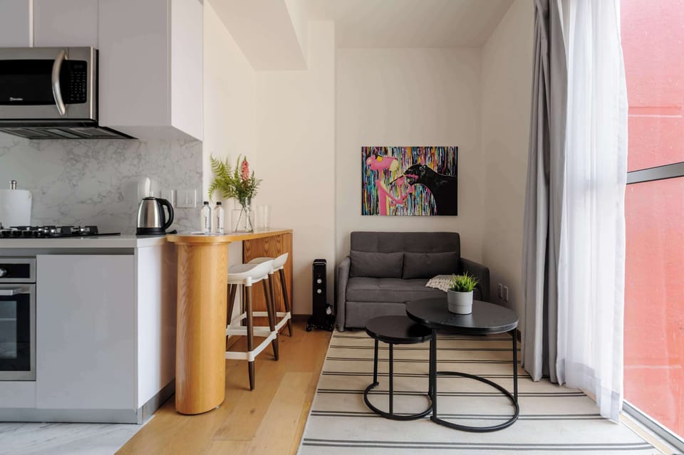 Cozy living area with artistic décor and natural sunlight throughout the space.
