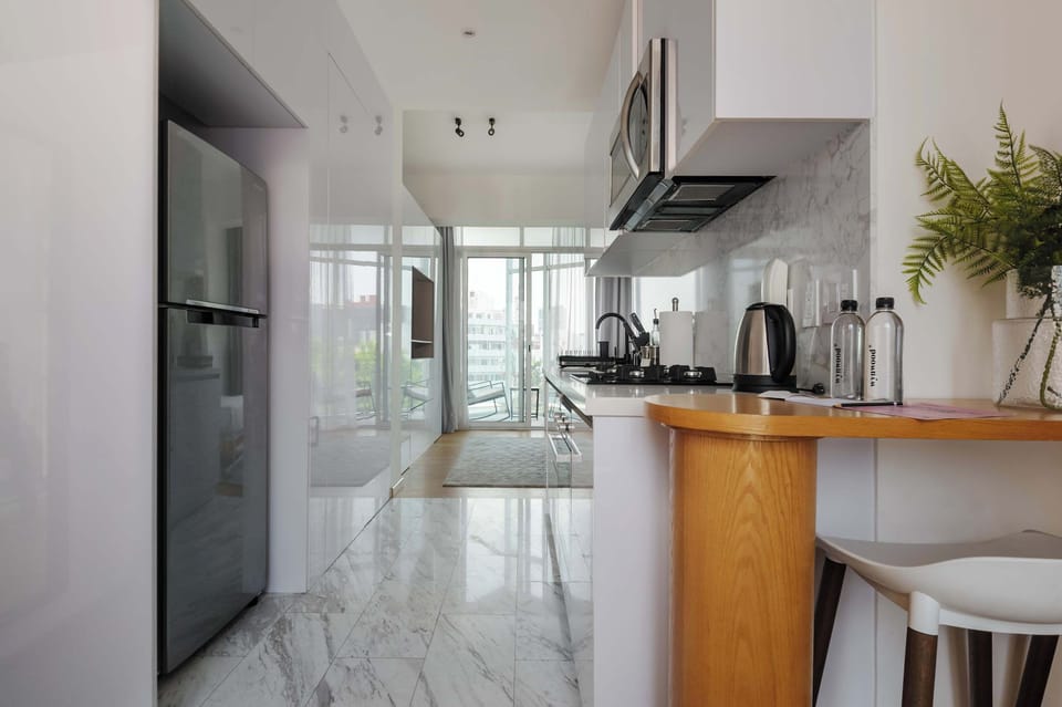 Stylish kitchen and dining area with marble-inspired finishes and modern appliances.
