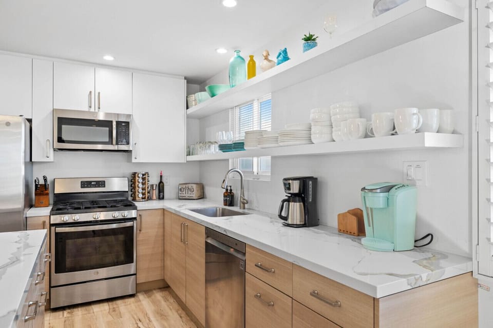 Prepare gourmet meals in this elegant kitchen, featuring a large island, modern appliances, and open shelving.
