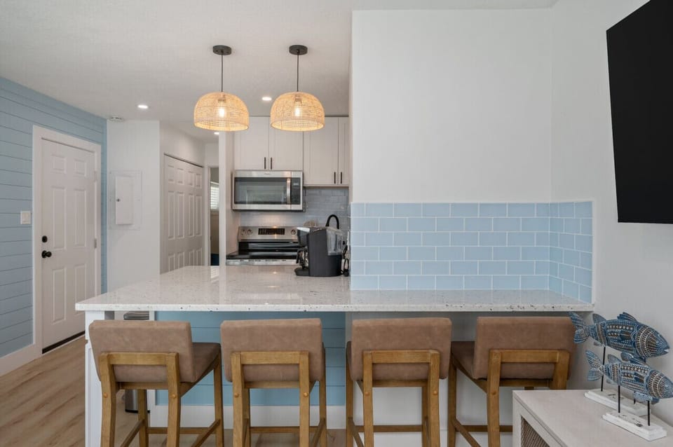Stylish lighting and sleek countertops make this kitchen a perfect spot to gather.