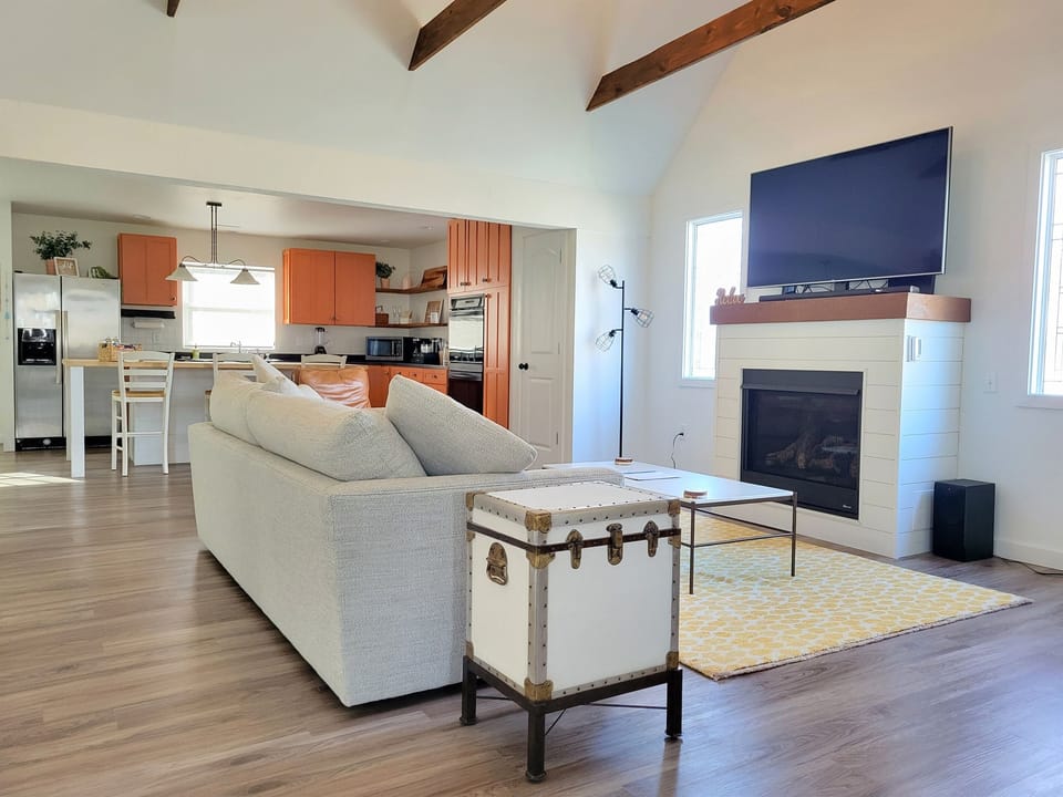 Living room with gas fireplace and comfy seating. Right off of the kitchen to maximize family time - whether you're cooking, watching the big game, or relaxing by the fire!