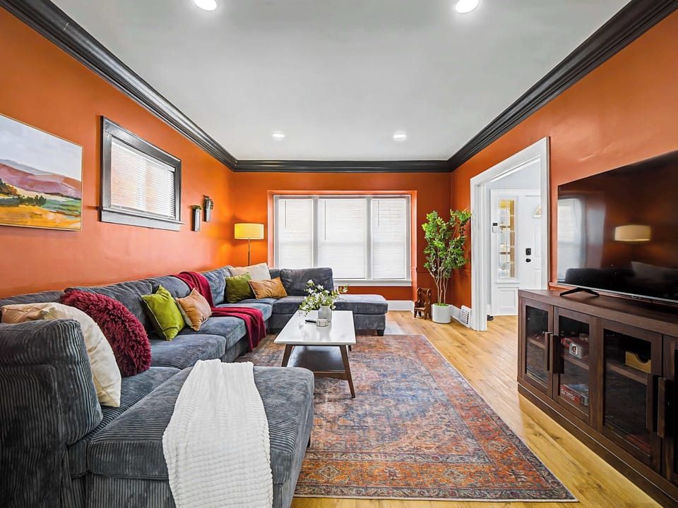 Inviting living room w/ plush seating, warm tones & a large TV for cozy movie nights