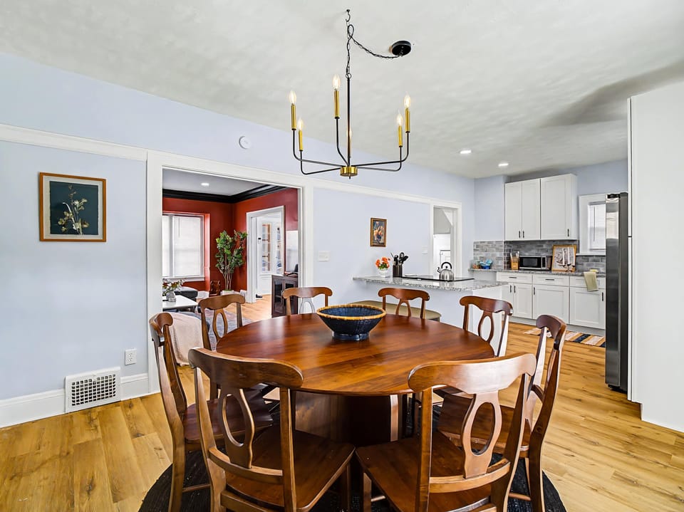 Dining area w/ round table, chandelier & open sightlines to the kitchen