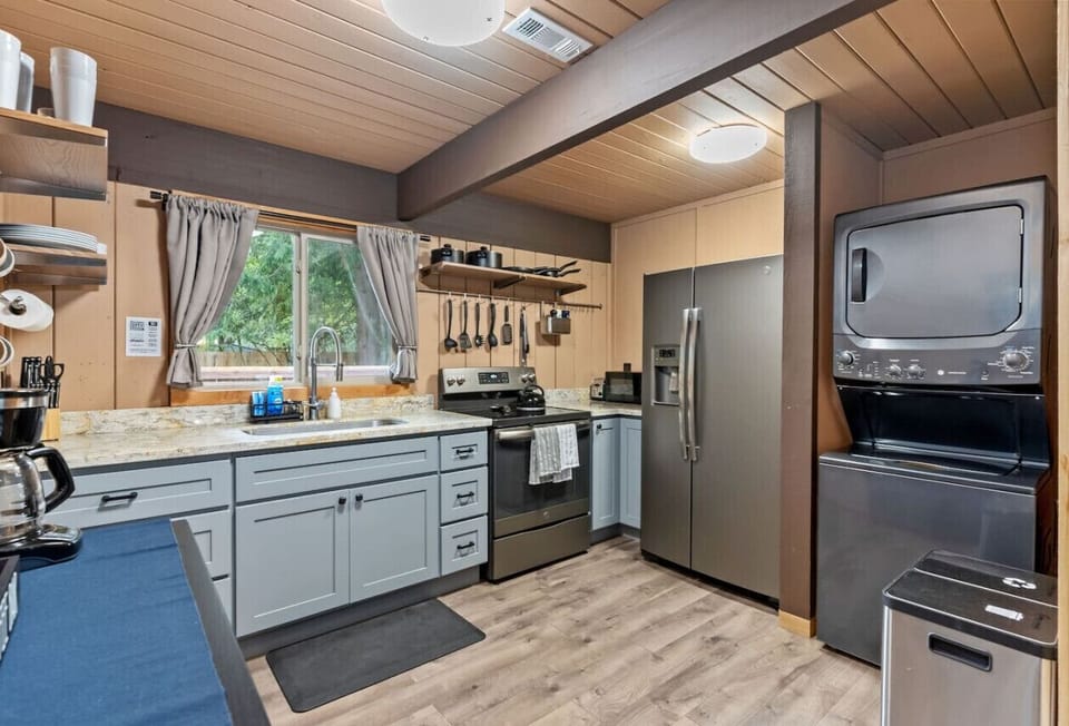 Kitchen w/ stove/oven, fridge/freezer, microwave, washer/dryer.