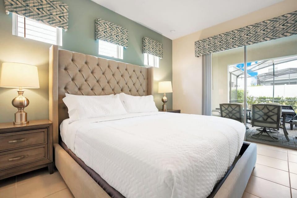 Relax in this modern bedroom with a tufted headboard and direct access to a screened patio.