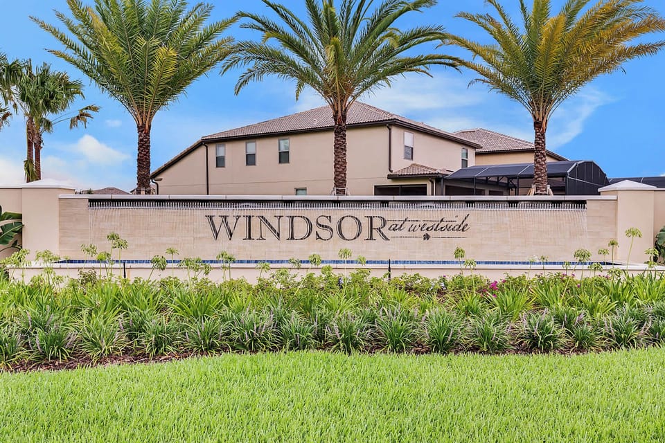 Entrance to windsor at westside featuring a water wall and palm trees