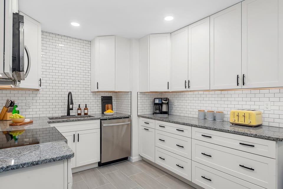You'll never run out of room in this expansive kitchen. Featuring two long stretches of granite countertops and floor-to-ceiling cabinetry, it’s perfectly equipped for meal prep and organization.