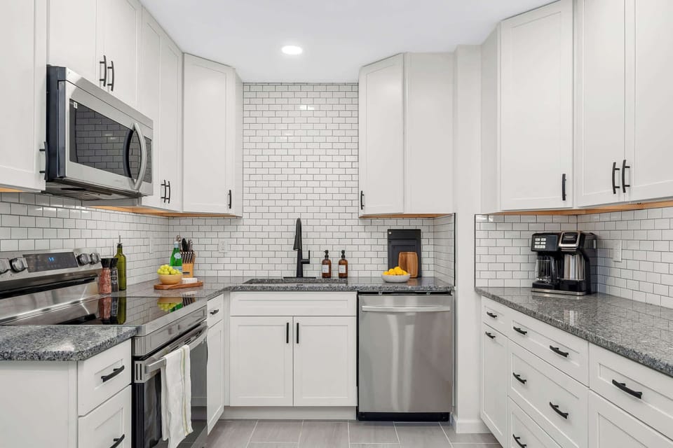 Modern culinary bliss. ✨ Enjoy a pristine kitchen featuring subway tile accents, stainless steel essentials, and all the tools needed for a perfect stay.
