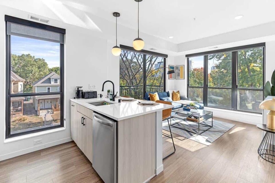 Bright, open layout with modern kitchen, cozy living area, and floor-to-ceiling windows.