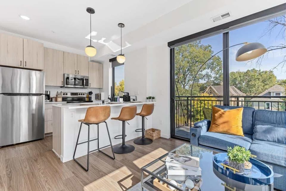 Bright open-concept kitchen with modern appliances, bar seating, and sunny views.
